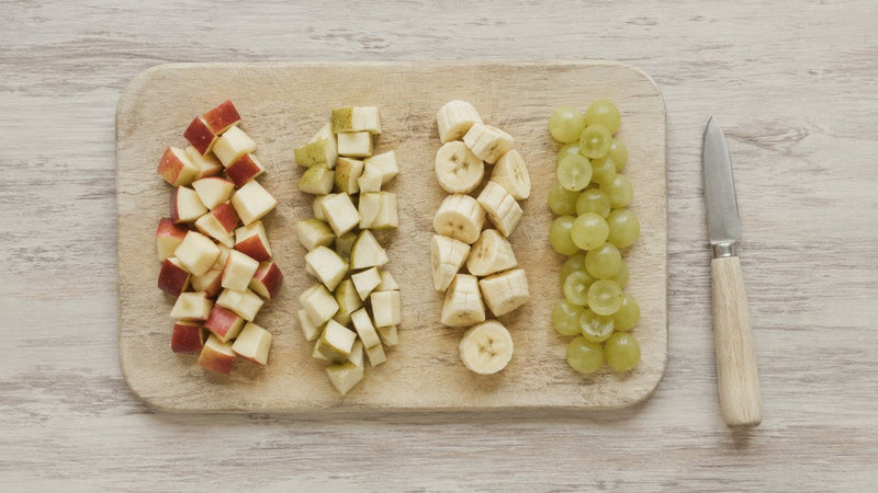 Couper les fruits d'un enfant selon leur forme et leur texture