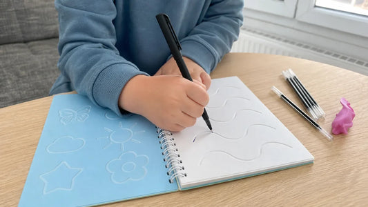 Main d'enfant qui suit une rainure d'un cahier magique avec le stylo