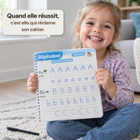 Une enfant montre la page de lettres qu'elle vient de tracer