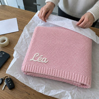 La couverture rose pliee dans du papier de soie, prete a offrir
