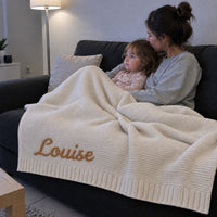 Une mere et sa fille sous la couverture sur le canape